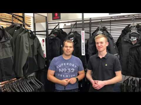 Sven Binder und Tobias Dees vor einem Regal mit Arbeitsjacken.